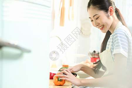 愉快的女人在厨房做美食图片