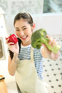 愉快的女人在厨房做美食图片