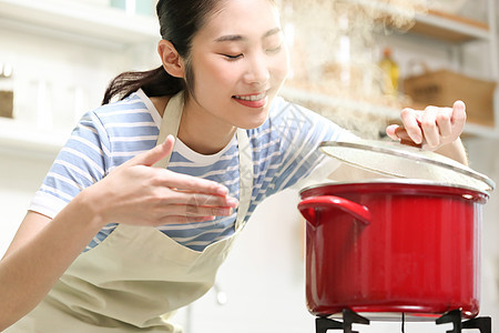 愉快的女人在厨房做美食图片