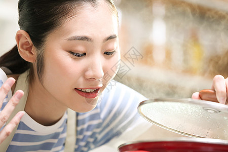 愉快的女人在厨房做美食图片