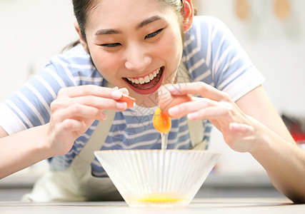 愉快的女人在厨房做美食图片