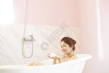 浴缸里洗泡泡浴的年轻女子图片