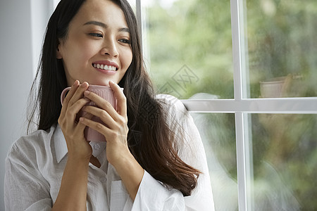 室内窗边喝茶的女人图片