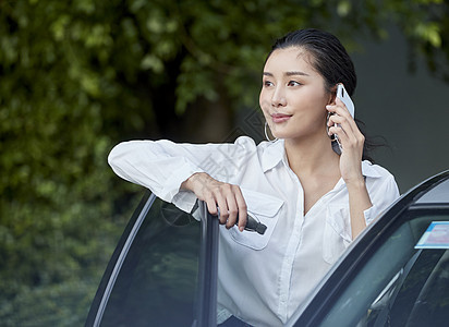 女人站在车边接打电话图片