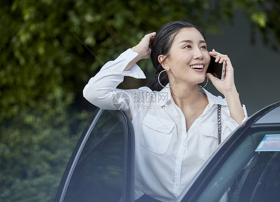 女人站在车边接打电话图片