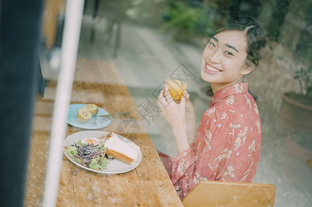 室内用餐的年轻女人看向窗外图片