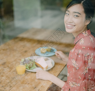 室内用餐的年轻女人看向窗外图片