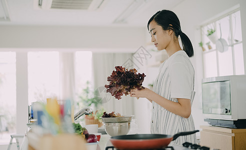 年轻女人在厨房做美食图片