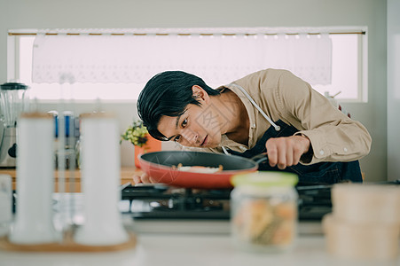 年轻男子在厨房做美食图片