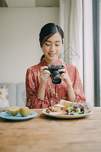 女性用相机拍摄菜品图片