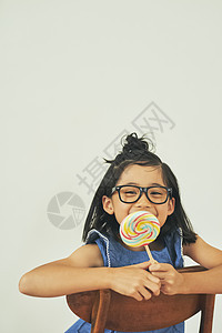 戴眼镜的可爱女孩吃棒棒糖图片