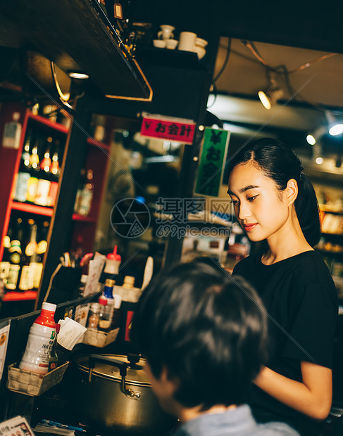 夜晚酒吧给顾客点餐的女人图片