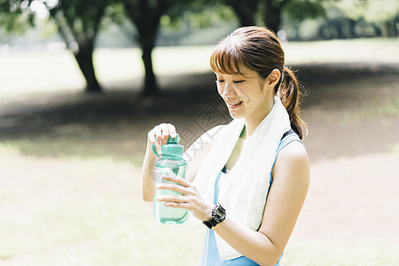 打开水瓶喝水的运动女性图片