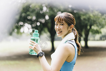 户外拿着水瓶的青年女子图片