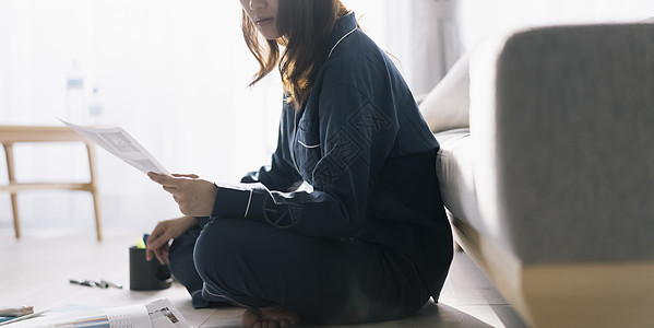 坐在地上看文件的女士图片