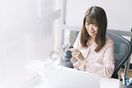 拿着相机研究的青年女子图片