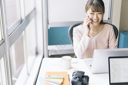 办公室接听电话微笑的女青年图片