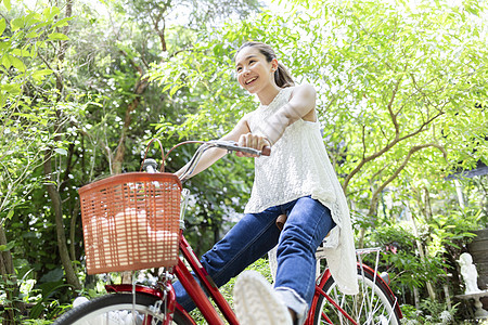 公园骑自行车微笑的年轻女子图片