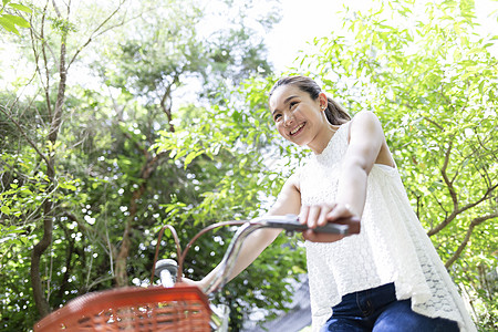 户外公园骑着自行车的青年女子图片