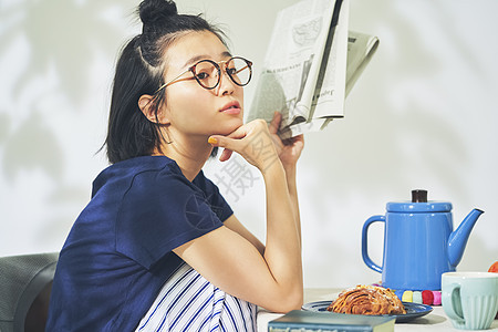 居家用餐拿着书的青年女子图片