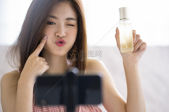 年轻女人手机视频直播分享美妆产品图片
