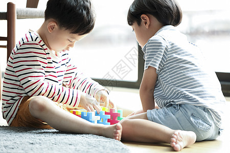 坐在地毯上玩积木的小孩子图片