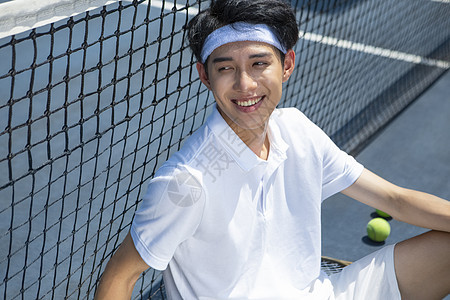 坐在网球场休息的青年男子图片