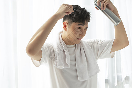 青年男性使用发胶喷雾做发型图片