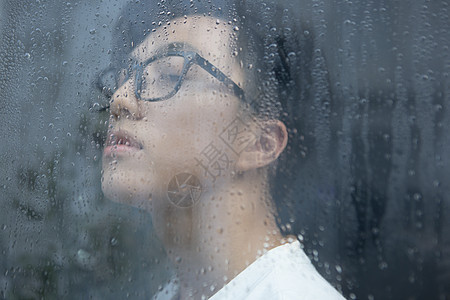 雨天看向窗外的青年男性图片