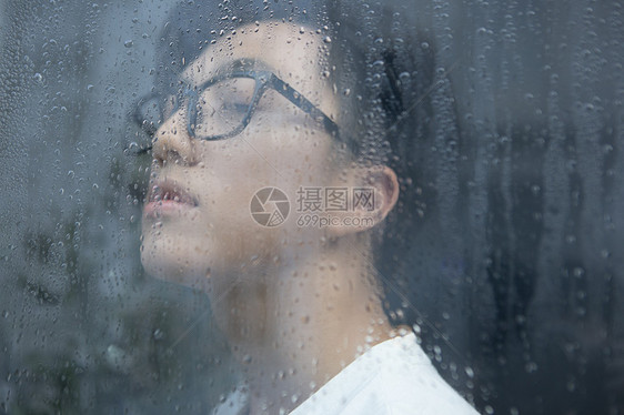 雨天看向窗外的青年男性图片