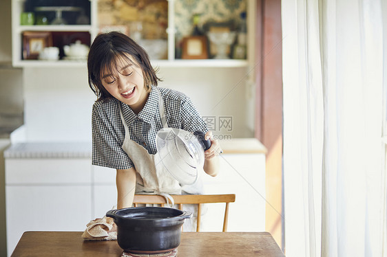 打开锅盖的年轻女子图片