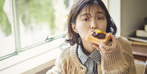 吃面包的年轻女子背景图片