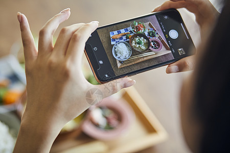 拿着手机拍食物照片特写图片