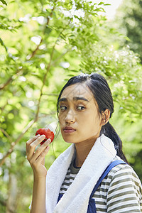 户外吃西红柿的女人图片