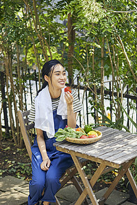 蔬菜园的妇女吃西红柿图片