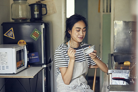 户内在厨房里吃饭的女人图片