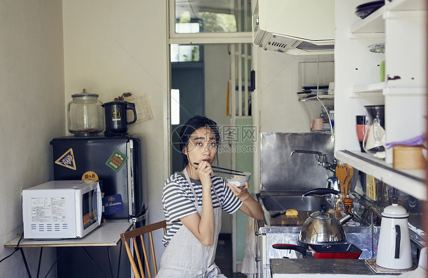 户内在厨房里吃饭的女人图片