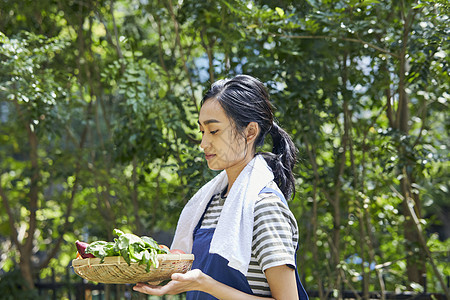 端着新鲜蔬菜的年轻女子图片