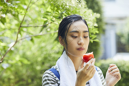 吃番茄的青年女子图片