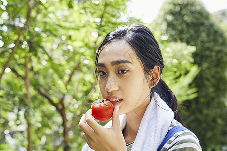 吃番茄的青年女子图片