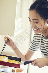 制作鸡蛋卷料理的年轻女子图片