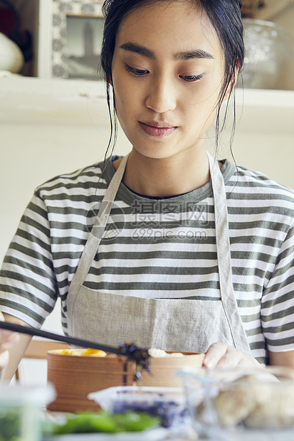 制作午餐盒便当的青年女子图片