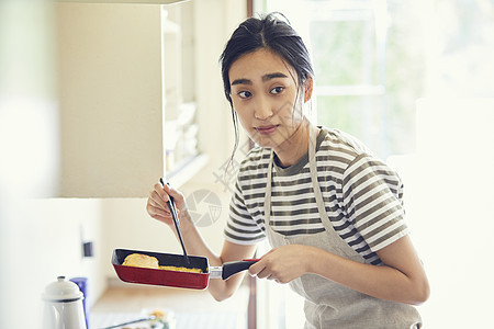 制作鸡蛋卷的年轻女子图片