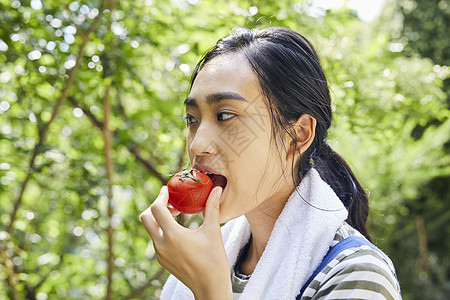 吃番茄的青年女子图片