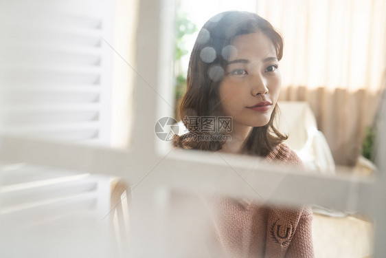 居家看向窗外的青年女子图片