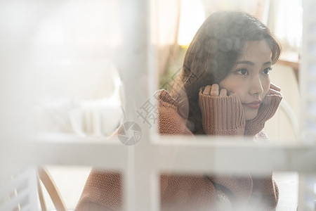 居家看向窗外思考的青年女子图片