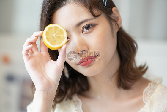 年轻健康美女手拿着柠檬图片