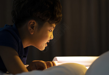 睡前阅读书籍的小男孩图片