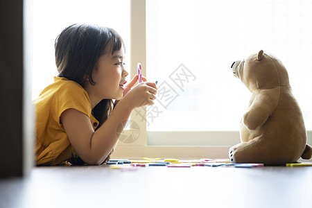 小女孩和玩具熊一起学习认识字母图片