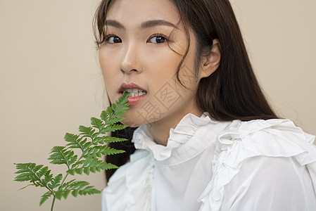 拿着叶子的美妆女性图片